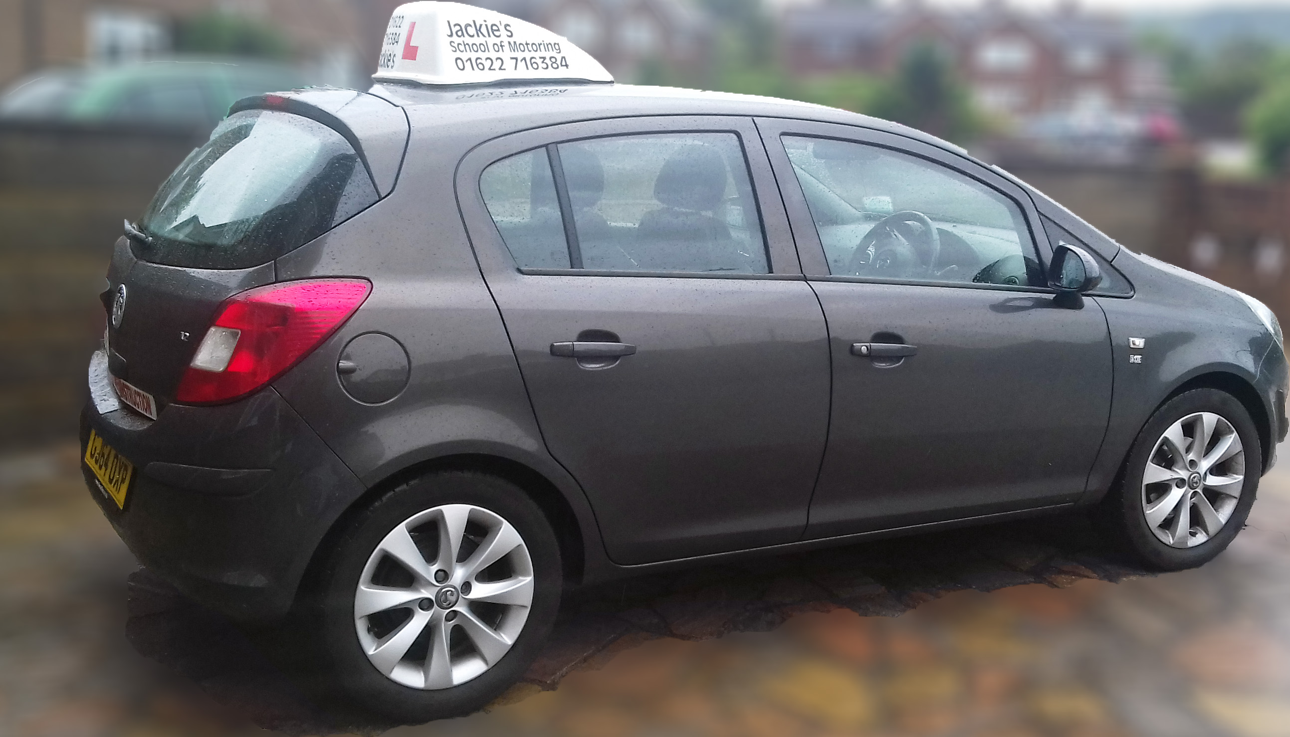 Grey Vauxhall Corsa tuition car with Jackie’s School of Motoring roof sign and L plate