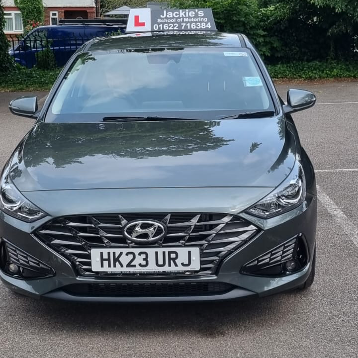 Dark Hyundai tuition car with L plate roof sign, front view